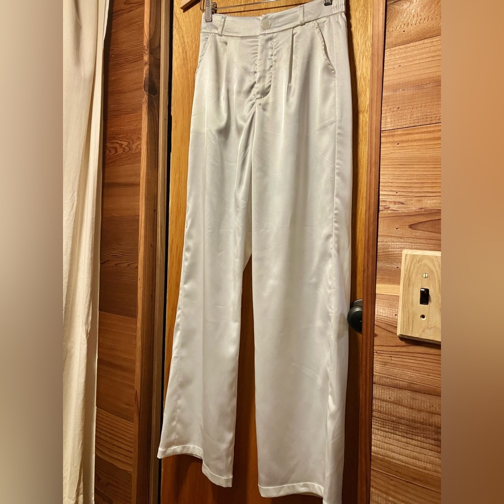 White high-waisted wide leg satin trousers.